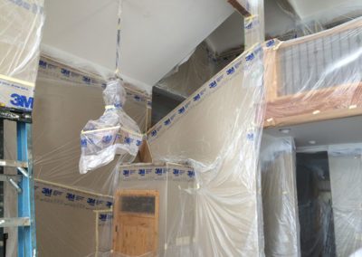 corner view of the house wrapped with polythene during painting