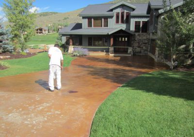 a painter is sprinkling the water on the driveway